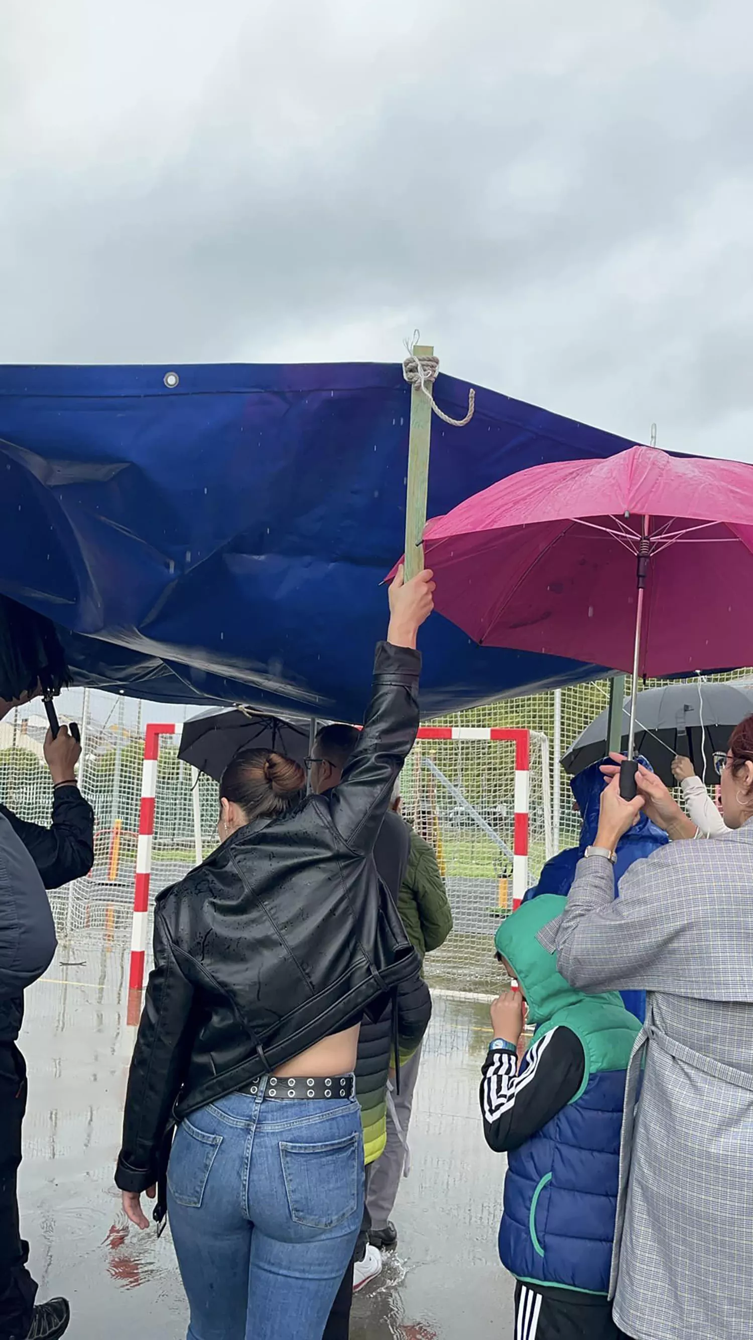 Una lona sirve de techo móvil a los niños del colegio de Columbrianos para disfrutar del recreo a pesar de la lluvia | FOTO: AMPA de Columbrianos