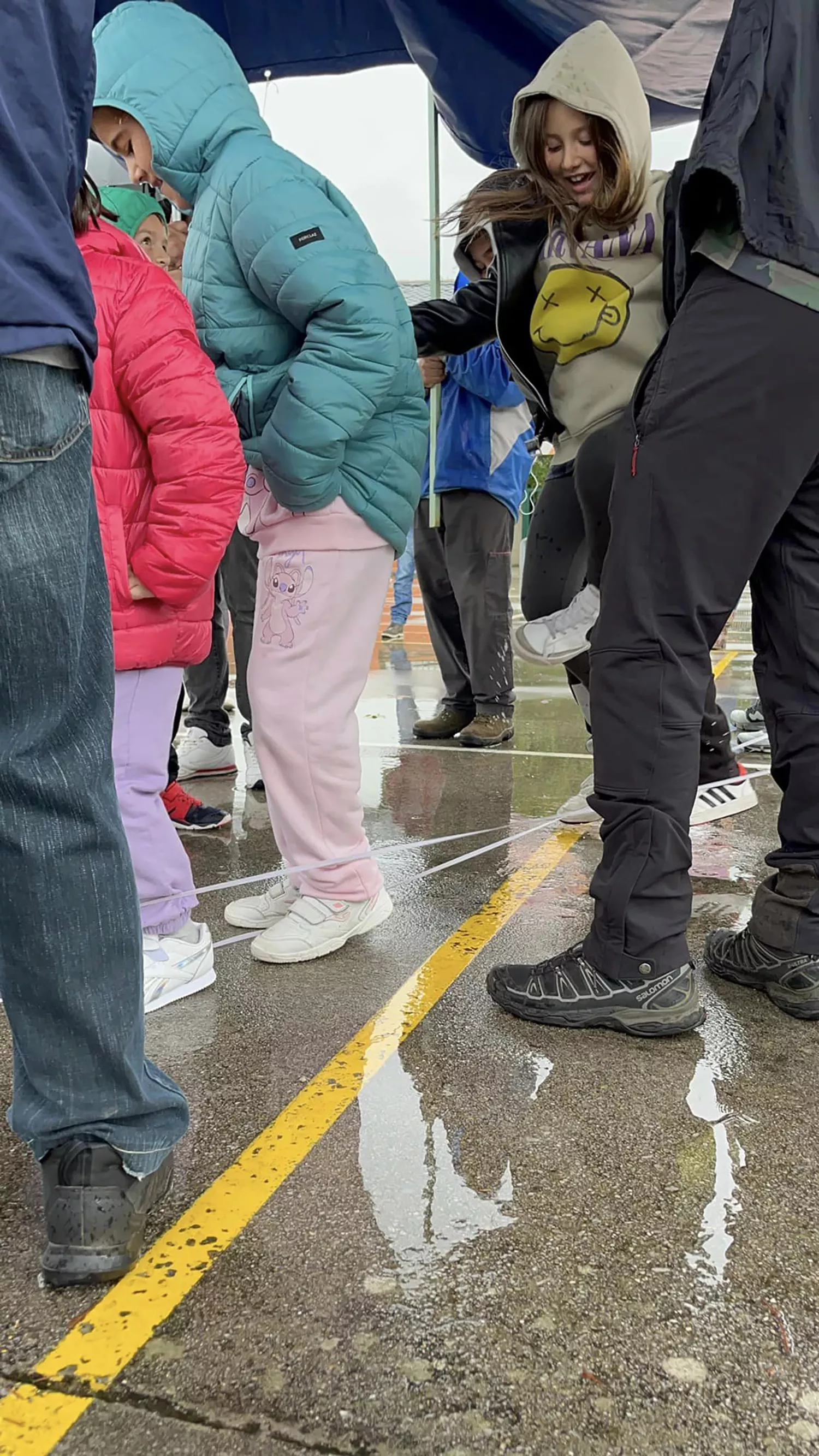 Una lona sirve de techo móvil a los niños del colegio de Columbrianos para disfrutar del recreo a pesar de la lluvia | FOTO: AMPA de Columbrianos