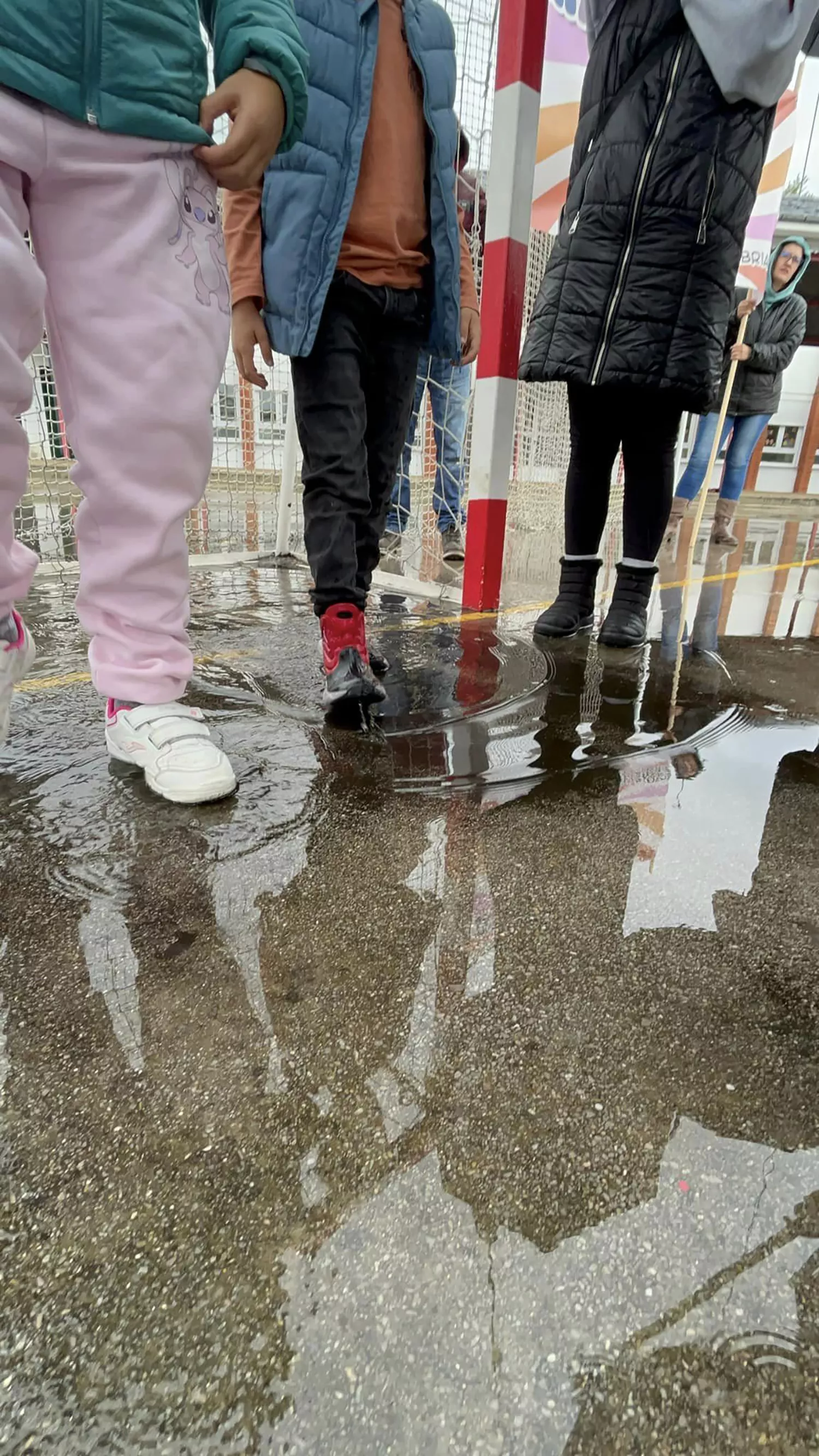 Una lona sirve de techo móvil a los niños del colegio de Columbrianos para disfrutar del recreo a pesar de la lluvia | FOTO: AMPA de Columbrianos