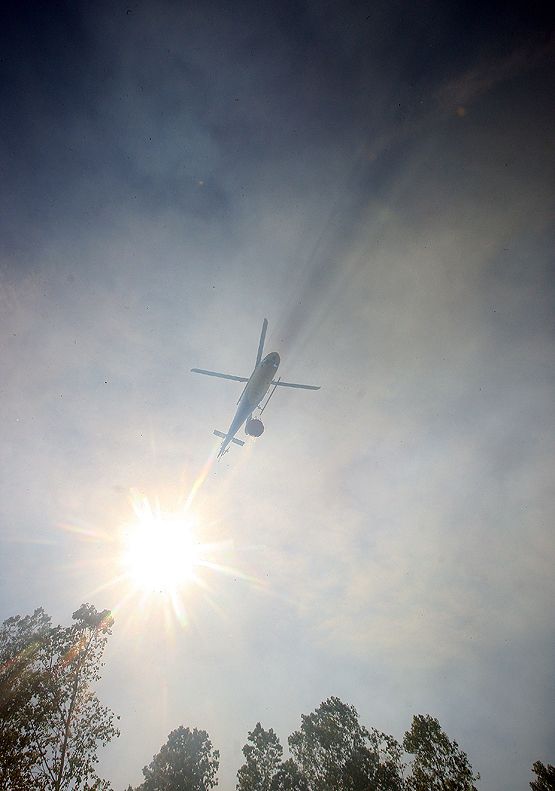 Un helicóptero interviene para refrescar la zona y evitar la expansión por el folín (C.S)